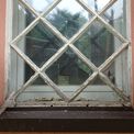 Eines der rund 160 Jahre alten Fenster am Treppenturm  bevor die Tischler die abblätternde Farbe abnahmen und das Holz freilegten. © Foto: BBL M-V