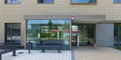 Der Haupteingang des Büro- und Verwaltungsgebäudes - im Spiegelbild das gegenüberliegende alte Rechenzentrum mit roter Fassade  welches nach Inbetriebnahme des neuen RZ abgebrochen wird. © 2020 SBL Greifswald
