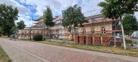Blick auf die eingerüstete Orangerie – die Dachziegel liegen schon zum Verlegen bereit © 2022 SBL Neubrandenburg