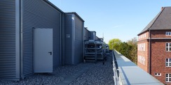 Die Technikzentrale auf dem Dach ist als zurückgesetztes Staffelgeschoss ausgebildet - im Hintergrund rechts das benachbarte denkmalgeschützte Gebäude der ehemaligen Urologischen Klinik © 2022 SBL Greifswald