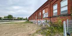 Blick auf das Baufeld mit dem angrenzenden, denkmalgeschützten Bestandsbauten © 2023 SBL Rostock